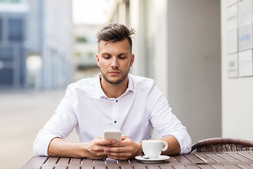 Image showing man with smartphone and coffee at city cafe