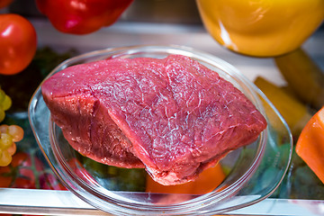 Image showing Fresh raw meat on a shelf open refrigerator