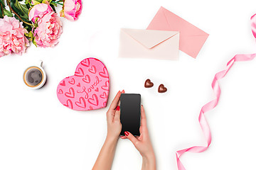 Image showing The female hands with phone and gift box on white background