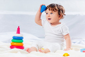 Image showing Happy baby boy sitting with toy