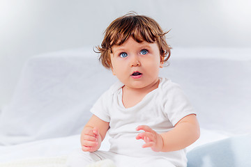 Image showing Happy baby boy sitting on gray