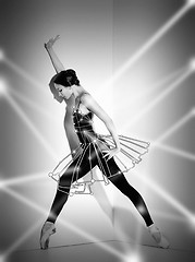 Image showing Ballerina in black outfit posing on pointe shoes, studio background.