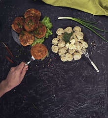 Image showing Fried cutlets and russian pelmeni on black background