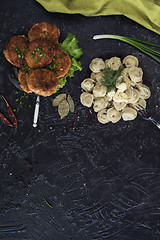 Image showing Fried cutlets and russian pelmeni on black background