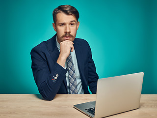 Image showing Sad Young Man Working On Laptop At Desk