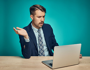 Image showing Sad Young Man Working On Laptop At Desk