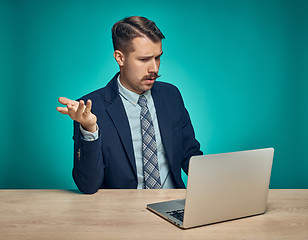 Image showing Sad Young Man Working On Laptop At Desk