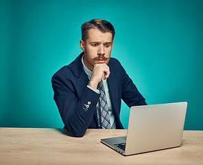 Image showing Sad Young Man Working On Laptop At Desk