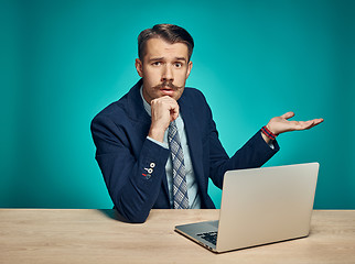 Image showing Sad Young Man Working On Laptop At Desk