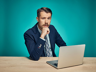 Image showing Sad Young Man Working On Laptop At Desk