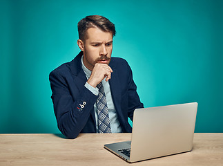 Image showing Sad Young Man Working On Laptop At Desk