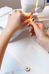 Image showing Seamstress makes stitch on sewing-machine