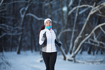 Image showing Woman jogging on winter forest