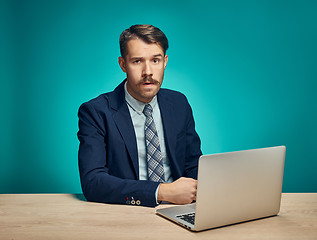 Image showing Sad Young Man Working On Laptop At Desk