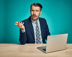 Image showing Sad Young Man Working On Laptop At Desk