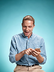 Image showing The young surprised caucasian man on blue background