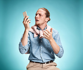 Image showing The young surprised caucasian man on blue background