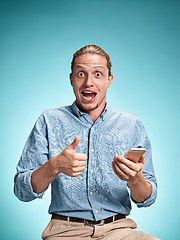 Image showing The young smiling caucasian man on blue background