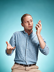 Image showing The young surprised caucasian man on blue background