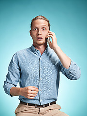 Image showing The young surprised caucasian man on blue background