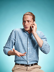 Image showing The young surprised caucasian man on blue background