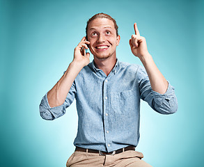 Image showing The young smiling caucasian man on blue background