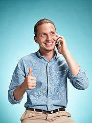 Image showing The young smiling caucasian man on blue background