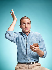 Image showing The young surprised caucasian man on blue background