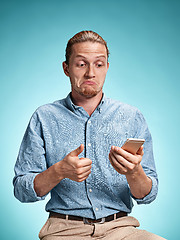 Image showing The young surprised caucasian man on blue background