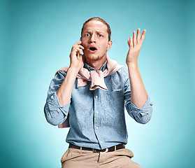 Image showing The young surprised caucasian man on blue background