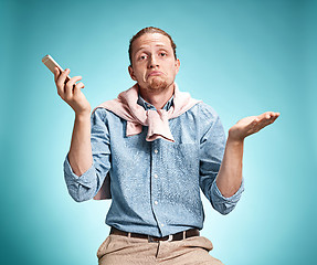 Image showing The young surprised caucasian man on blue background