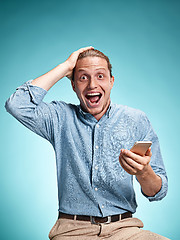 Image showing The young smiling caucasian man on blue background