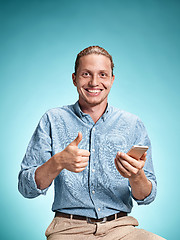 Image showing The young smiling caucasian man on blue background