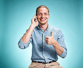 Image showing The young smiling caucasian man on blue background