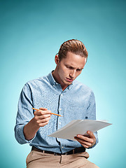 Image showing Smart sad student with sheets of paper