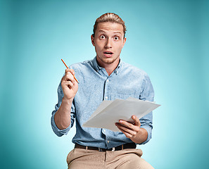 Image showing Smart surprised student with great idea holding sheets of paper