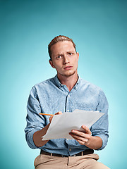 Image showing Smart sad student with sheets of paper