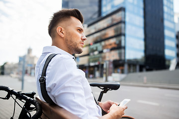 Image showing man with smartphone and bicycle in city