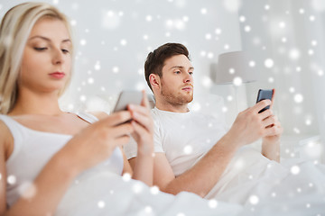 Image showing couple with smartphones in bed