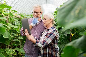 Image showing senior couple with tablet pc at farm greenhouse