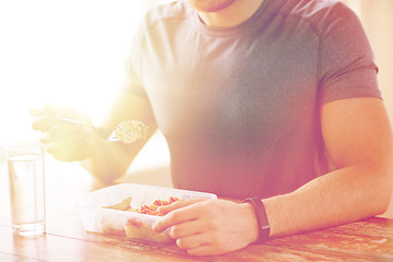 Image showing close up of man with fork and water eating food