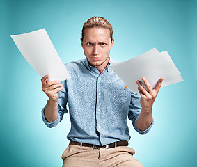 Image showing Smart smiling student with great idea holding sheets of paper