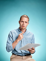 Image showing Smart sad student with sheets of paper