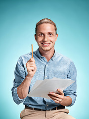Image showing Smart smiling student with great idea holding sheets of paper