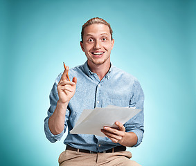 Image showing Smart smiling student with great idea holding sheets of paper