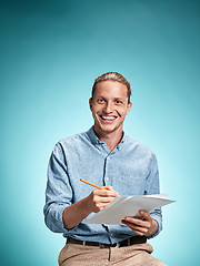 Image showing Smart smiling student with great idea holding notebook