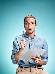 Image showing Smart surprised student with great idea holding sheets of paper