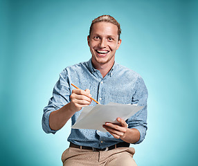 Image showing Smart smiling student with great idea holding sheets of paper