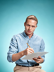 Image showing Smart sad student with sheets of paper