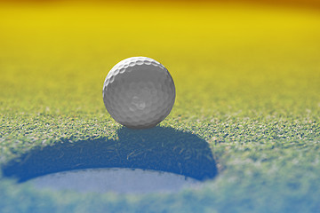 Image showing golf ball on lip of cup
